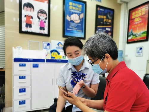 建行成都第六支行，大堂經(jīng)理為客戶介紹手機(jī)銀行“大字”模式
